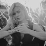 Model sitzend mit Schmuck, Ringen, Ohrringen und einer Halskette